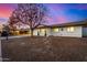 Home exterior with tidy landscaping and warm lighting at dusk at 1708 W Harmont Dr, Phoenix, AZ 85021