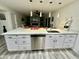 Spacious kitchen with a stainless steel dishwasher, modern pendant lights, and ample counter space at 1708 W Harmont Dr, Phoenix, AZ 85021