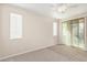 Spacious bedroom with plush carpeting, ceiling fan, and sliding glass door to patio at 17722 W Banff Ln, Surprise, AZ 85388