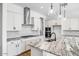 Modern kitchen with white cabinets, granite countertops, and stainless steel appliances at 20019 W Campbell Ave, Buckeye, AZ 85396