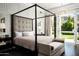 Elegant bedroom with a four-poster bed and access to a private backyard at 21487 N 110Th Pl, Scottsdale, AZ 85255