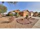 Tan house with a two-car garage and desert landscaping at 2608 E Desert Wind Dr, Casa Grande, AZ 85194