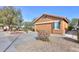 Tan house with a two-car garage and desert landscaping at 2608 E Desert Wind Dr, Casa Grande, AZ 85194