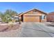 Tan house with a two-car garage and desert landscaping at 2608 E Desert Wind Dr, Casa Grande, AZ 85194