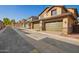 Row of tan two-story townhomes, each featuring a private two-car garage and desert landscaping at 2828 N Evergreen St, Buckeye, AZ 85396