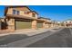 Townhomes with two-car garages line the street, showcasing contemporary design and well-maintained curb appeal at 2828 N Evergreen St, Buckeye, AZ 85396