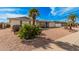 Well-maintained single-story home featuring desert landscaping with rocks, plants and a palm tree at 5433 E Dodge St, Mesa, AZ 85205