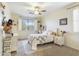 Bright bedroom with a white bed frame, ceiling fan, and a large window with shutter blinds at 5613 W West Wind Dr, Glendale, AZ 85310