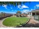 Expansive backyard features a grass patch, pergola with seating, desert landscaping, and privacy fence at 8479 E Sunrise Sky Dr, Gold Canyon, AZ 85118