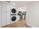 Modern kitchen with stainless steel appliances, white cabinets, and stacked washer/dryer at 9270 E Mission Ln # 117, Scottsdale, AZ 85258