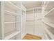 Spacious walk-in closet with custom shelving and wood-look tile floors at 9270 E Mission Ln # 117, Scottsdale, AZ 85258