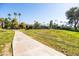 Well-maintained walking path through grassy area with views of palm trees and residential buildings at 9270 E Mission Ln # 117, Scottsdale, AZ 85258