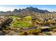 Stunning aerial view of the golf course community with mountain views, lush landscaping, and beautiful homes at 10306 E Rising Sun Pl, Gold Canyon, AZ 85118