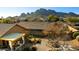 Backyard view with desert landscaping, garden beds, and covered patio at 10306 E Rising Sun Pl, Gold Canyon, AZ 85118