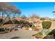 A desert landscaped backyard with gravel, desert plants, bushes, trees and outdoor seating area at 10306 E Rising Sun Pl, Gold Canyon, AZ 85118