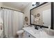 Well-lit bathroom with a shower-tub combo, neutral tones, and a large framed mirror at 10306 E Rising Sun Pl, Gold Canyon, AZ 85118