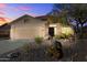 Inviting home with desert landscaping, two car garage and warm exterior lighting at 10306 E Rising Sun Pl, Gold Canyon, AZ 85118