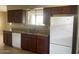 Kitchen with granite countertops, dark wood cabinets, and a dishwasher at 10365 W Pinehurst Dr, Sun City, AZ 85351