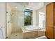 Bathroom with shower, soaking tub and large window at 10531 E Fernwood Ln, Scottsdale, AZ 85262