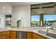 Modern kitchen with light wood cabinets and a double sink at 10531 E Fernwood Ln, Scottsdale, AZ 85262