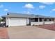 Front view of a ranch-style house with a white garage door at 10531 W Prairie Hills Cir, Sun City, AZ 85351