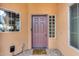 Home exterior featuring a purple door, brick flooring, and side windows at 11259 W Harrison St, Avondale, AZ 85323