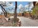 Landscaped front entry with brick paving, mature trees, and a seating area at 11259 W Harrison St, Avondale, AZ 85323