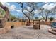 Brick paved patio with a water well feature, mature trees, and seating at 11259 W Harrison St, Avondale, AZ 85323