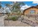 Landscaped front yard with a wooden bridge, stone accents, and drought-tolerant plants at 11259 W Harrison St, Avondale, AZ 85323