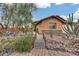 Charming home with xeriscaped front yard, featuring a wooden footbridge and various cacti at 11259 W Harrison St, Avondale, AZ 85323