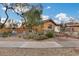 Single-story home with desert landscaping, a brick pathway, and a wrought iron bridge at 11259 W Harrison St, Avondale, AZ 85323