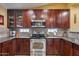 Well-equipped kitchen featuring dark wood cabinets, stainless steel appliances, and granite countertops at 11259 W Harrison St, Avondale, AZ 85323