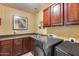 Bright laundry room with washer, dryer, and ample cabinetry at 11259 W Harrison St, Avondale, AZ 85323