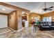 Open living room with tiled floors, a kitchen passthrough, and a leather sofa at 11259 W Harrison St, Avondale, AZ 85323