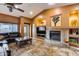 Spacious living room with a tile fireplace, built-in shelving, and a ceiling fan at 11259 W Harrison St, Avondale, AZ 85323