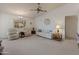 Comfortable living room with beige carpet, a couch, two armchairs, and ceiling fan at 12734 W Crystal Lake Dr, Sun City West, AZ 85375