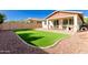 Artificial turf, covered patio, and a dog house are featured in this backyard at 12791 W Caraveo Pl, Peoria, AZ 85383