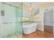 Elegant bathroom features a soaking tub under a window and a glass-enclosed shower at 1450 W Sea Haze Dr, Gilbert, AZ 85233