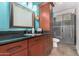 Stylish bathroom features a dark wood vanity, black countertop, and glass shower door at 1450 W Sea Haze Dr, Gilbert, AZ 85233