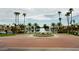 Beautiful waterfront community with lush landscaping, palm trees, and a large circular fountain in a roundabout at 1450 W Sea Haze Dr, Gilbert, AZ 85233