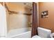 Bathroom features a shower-tub combo with tile surround and a toilet with a dark brown wall at 15838 E Thistle Dr, Fountain Hills, AZ 85268