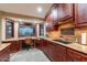 Kitchen with dark wood cabinets and granite countertops also featuring a desk and large windows at 15838 E Thistle Dr, Fountain Hills, AZ 85268