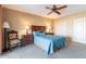 A bedroom with a blue quilt on the bed, lamps on the nightstands, a chair, and a ceiling fan at 15838 E Thistle Dr, Fountain Hills, AZ 85268