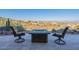 Desert views enjoyed from a cozy patio with comfortable seating around a stone fire pit for outdoor living and entertainment at 15838 E Thistle Dr, Fountain Hills, AZ 85268