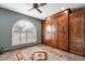 Spare bedroom features a ceiling fan, shutters, a large round rug and a Murphy bed at 15838 E Thistle Dr, Fountain Hills, AZ 85268