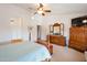 Main bedroom with wooden furniture and a large TV at 15973 W Sheila Ln, Goodyear, AZ 85395