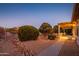 Evening view of backyard patio with pergola, seating area, and landscaping at 16442 W Quarry Ct, Surprise, AZ 85374