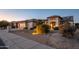 Single-story home with a two-car garage and attractive landscaping at dusk at 16442 W Quarry Ct, Surprise, AZ 85374