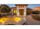 Welcoming front entrance with decorative iron gate and landscape lighting at 16442 W Quarry Ct, Surprise, AZ 85374