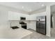 White kitchen with stainless steel appliances and quartz countertops at 19457 W Highland Ave, Litchfield Park, AZ 85340